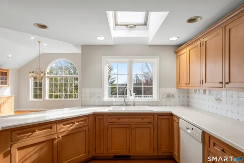 a kitchen with granite countertop a sink window and cabinets