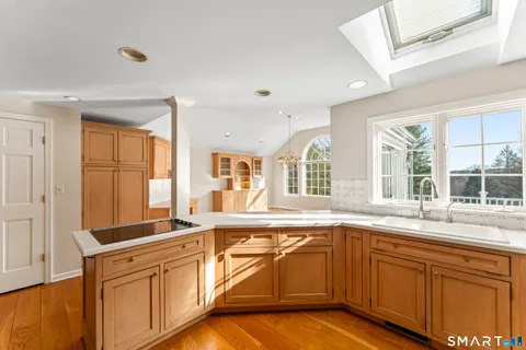 a kitchen with stainless steel appliances granite countertop a sink and cabinets with wooden floor
