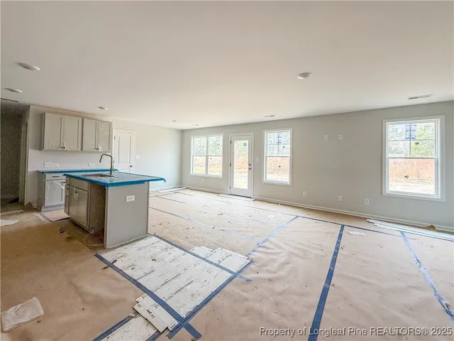 a room with a stove a sink a window and cabinets