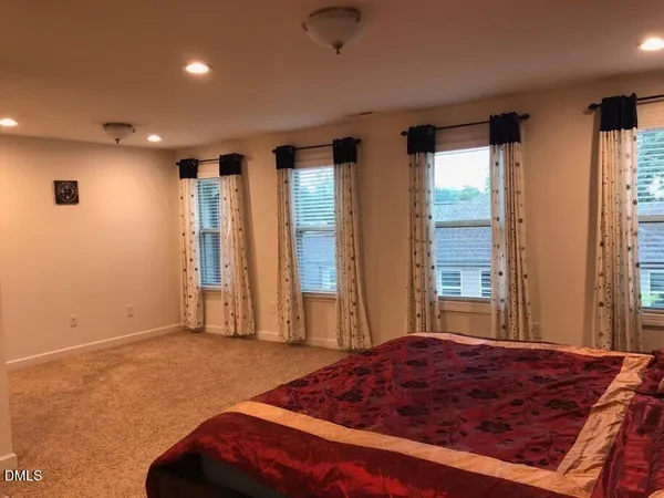 a spacious bedroom with a large bed and a large window