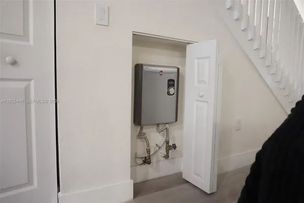 a view of a hallway with wooden floor and a potted plant