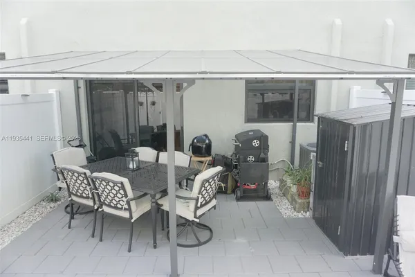 a view of a patio with table and chairs with wooden fence