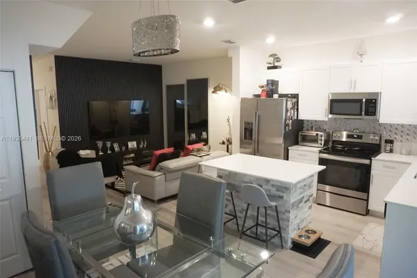a kitchen with stainless steel appliances kitchen island granite countertop a sink and cabinets