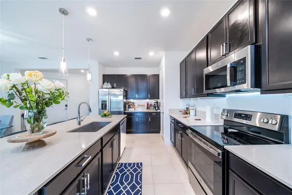 a kitchen with sink stove and refrigerator