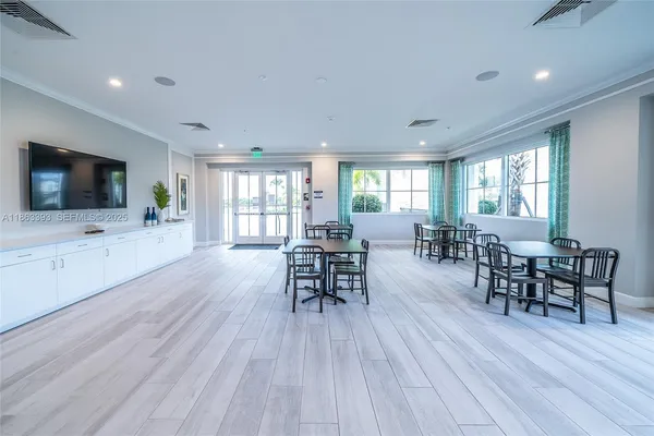 a open kitchen with stainless steel appliances granite countertop a refrigerator dining table and chairs