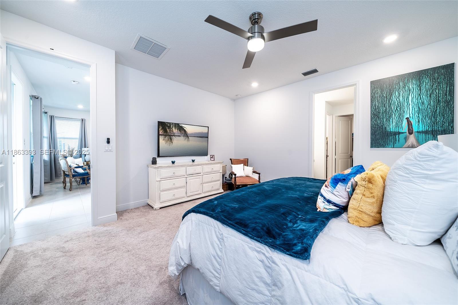 4230 Rosa Drive Deerfield Beach, FL 33064 - Photo 24 of 52 a bedroom with a large bed a flat tv screen and a view of bathroom