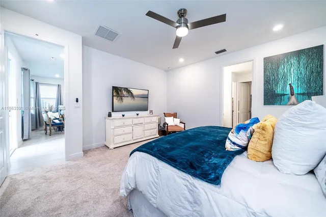 a bedroom with a large bed a flat tv screen and a view of bathroom