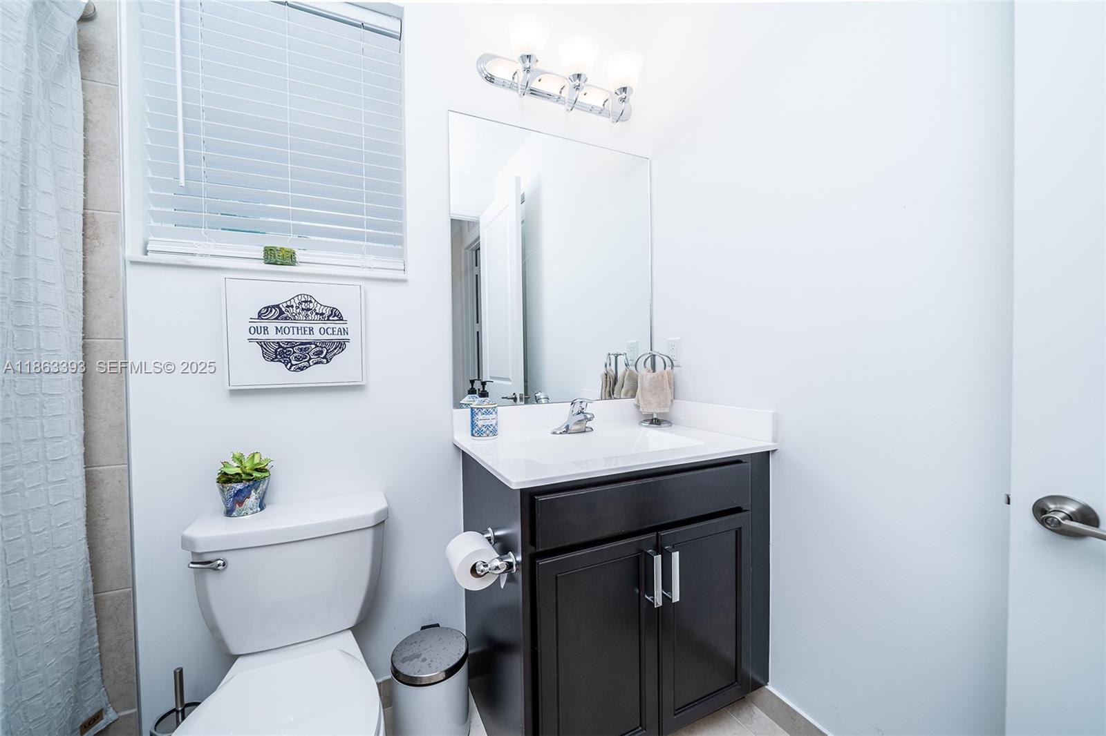4230 Rosa Drive Deerfield Beach, FL 33064 - Photo 35 of 52 a bathroom with a sink a toilet and a mirror
