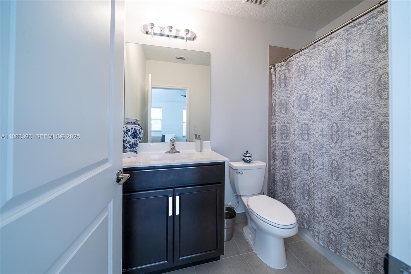 4230 Rosa Drive Deerfield Beach, FL 33064 - Photo 46 of 52 a bathroom with a sink a toilet and mirror