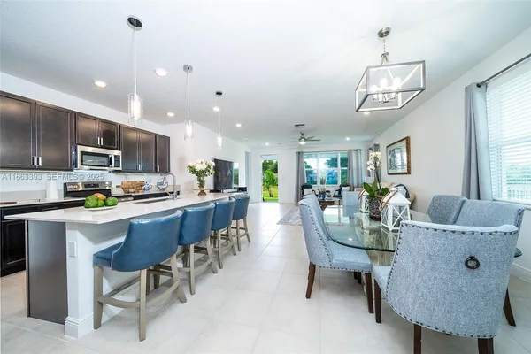 a view of kitchen with refrigerator stove dining table and chairs