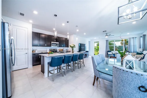 a kitchen with sink a refrigerator and chairs