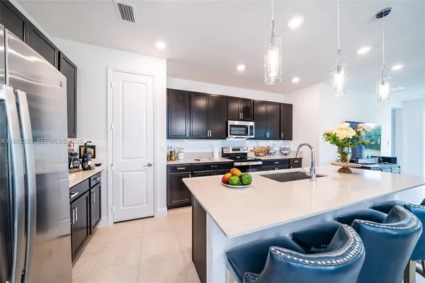 a kitchen with kitchen island a appliances a sink and a living room view