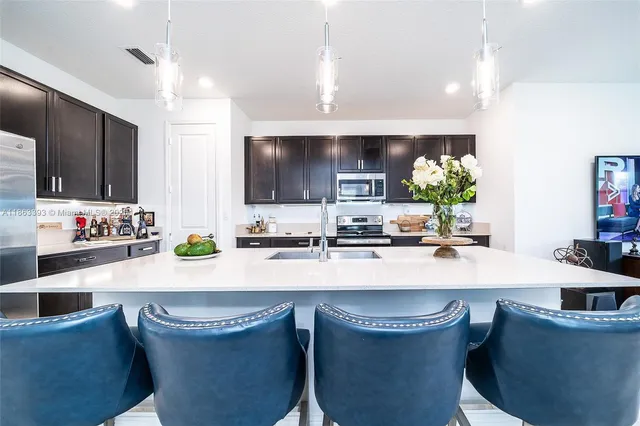a kitchen with granite countertop a sink and white cabinets