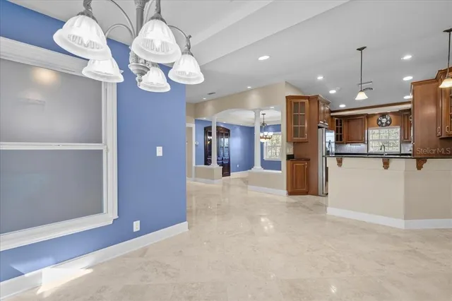 a kitchen with stainless steel appliances kitchen island granite countertop a refrigerator and cabinets