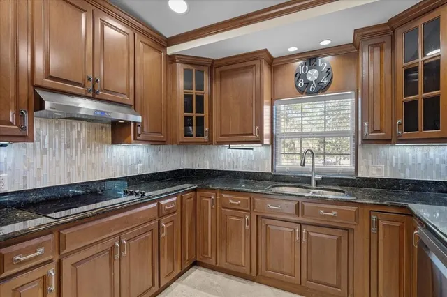 a kitchen with granite countertop stainless steel appliances and white cabinets