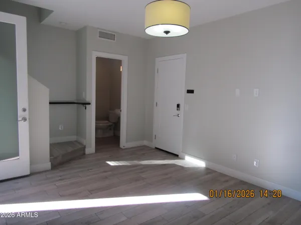 an empty room with wooden floor and windows