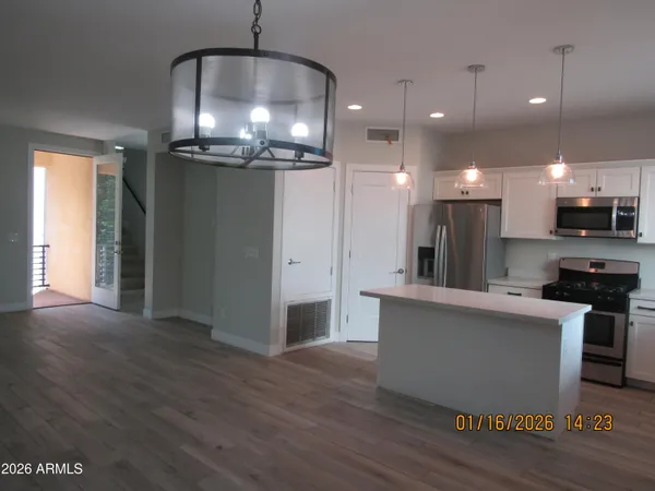 a open kitchen with stainless steel appliances granite countertop a stove and a refrigerator
