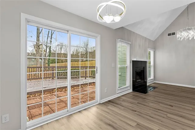 an empty room with wooden floor cabinet and windows