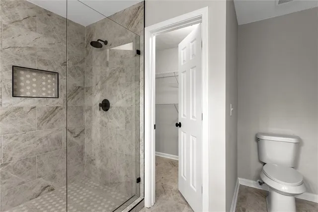 a bathroom with a toilet and a shower