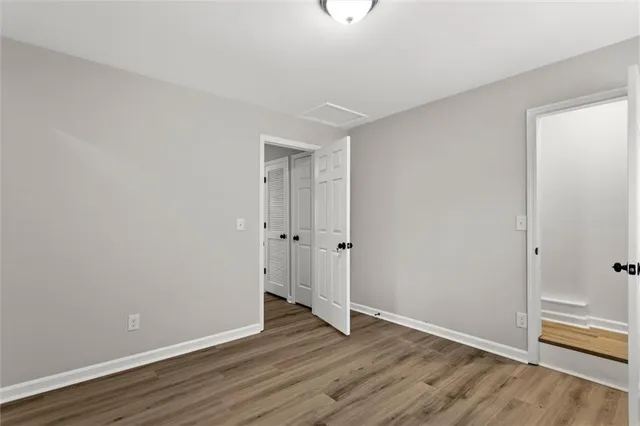 a view of an empty room with wooden floor