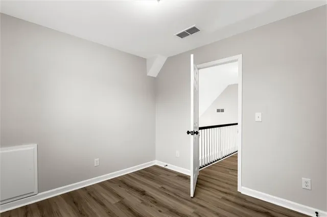 a view of an empty room with wooden floor