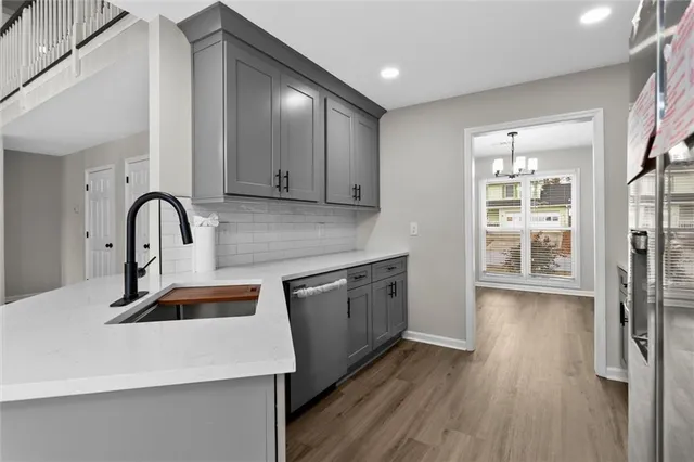 a kitchen with stainless steel appliances granite countertop a sink a stove and wooden floor