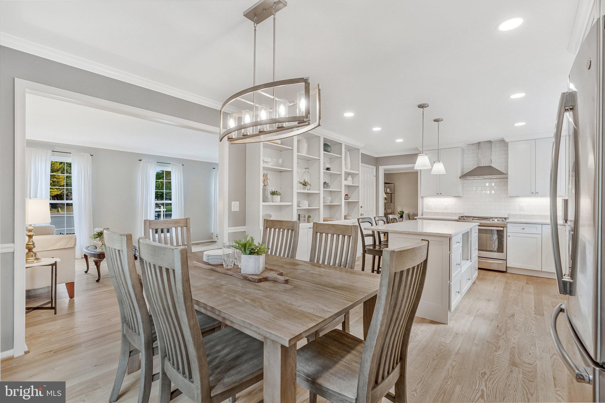 7 South Lowery Court Sterling, VA 20165 - Photo 14 of 63 a kitchen with stainless steel appliances kitchen island granite countertop a dining table chairs and white cabinets