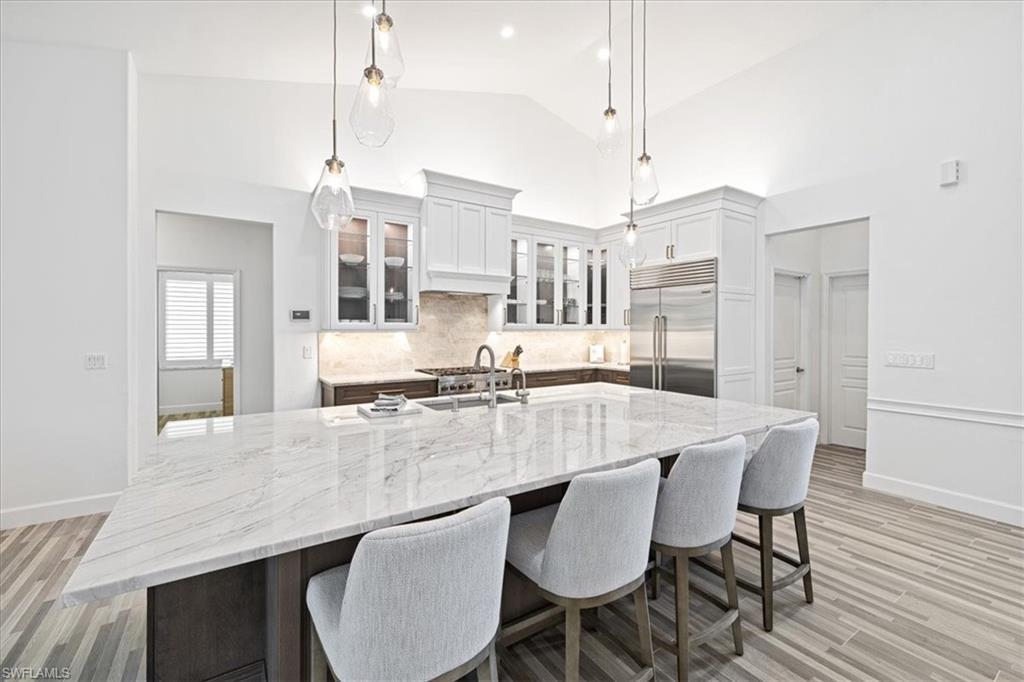 2032 Prince Drive Naples, FL 34110 - Photo 8 of 44 a large kitchen with granite countertop a stove a sink a dining table and chairs