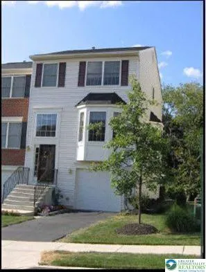 a front view of a house with a yard garage and tree