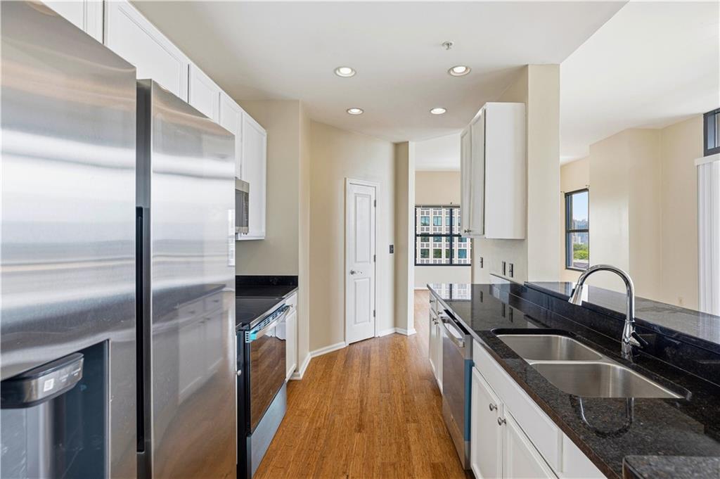 3040 Peachtree Road Northwest, Unit 1503 Atlanta, GA 30305 - Photo 9 of 38 a kitchen with kitchen island a sink appliances and cabinets