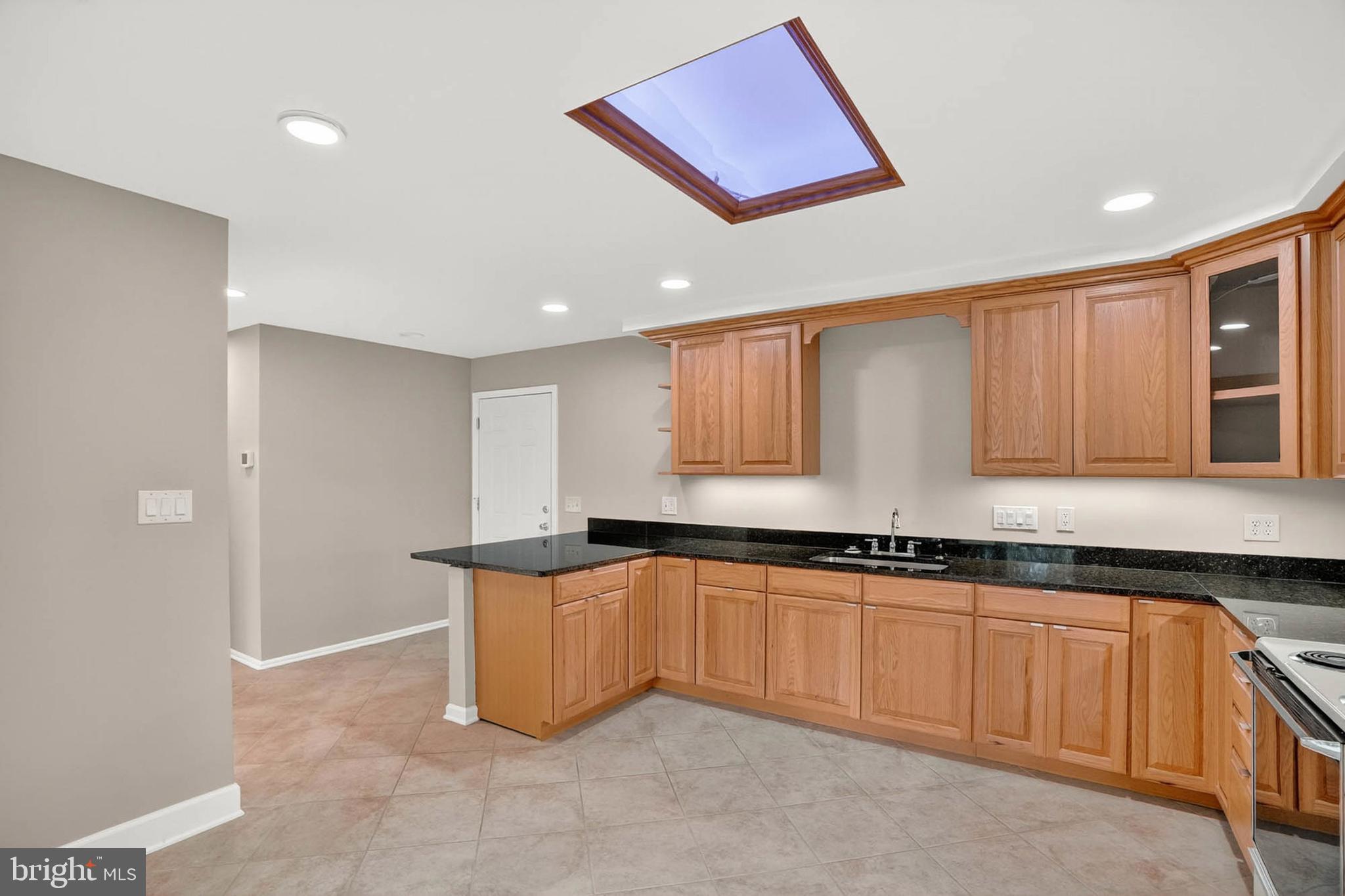 8203 Willow Street Laurel, MD 20707 - Photo 15 of 41 a kitchen with granite countertop a sink and cabinets