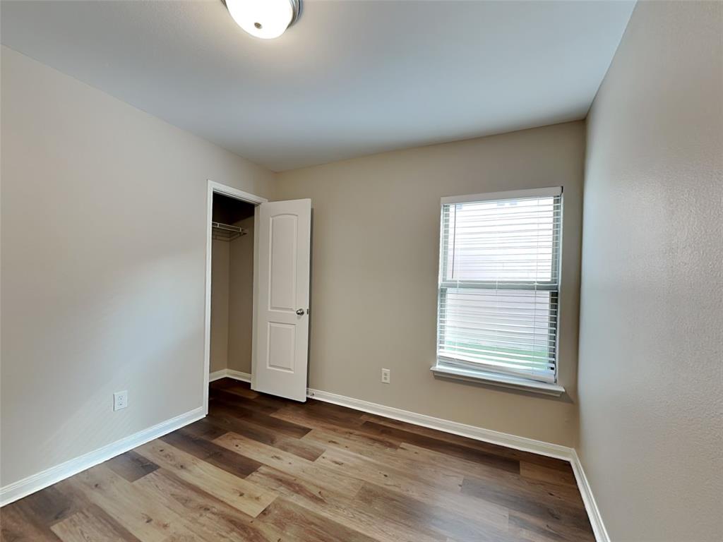 1334 Barrel Drive Dallas, TX 75253 - Photo 13 of 16 an empty room with wooden floor and windows