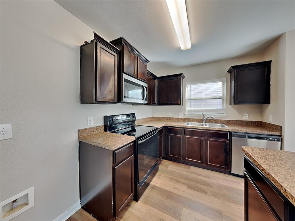 1334 Barrel Drive Dallas, TX 75253 - Photo 2 of 16 a kitchen with stainless steel appliances granite countertop a sink stove and microwave