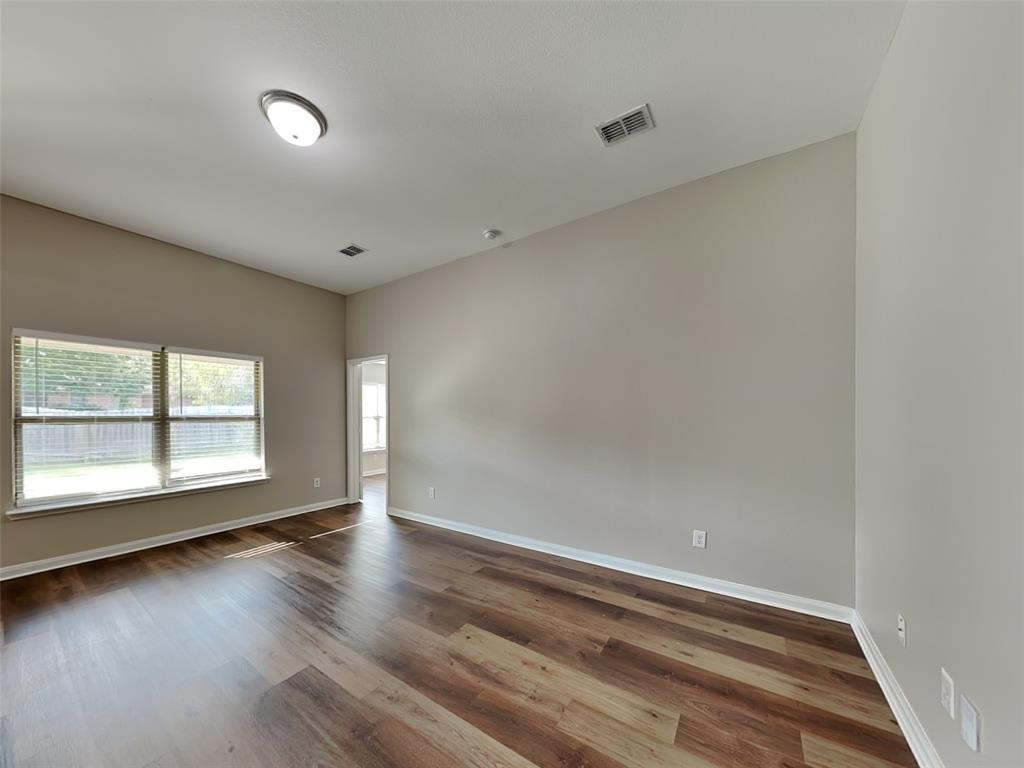 1334 Barrel Drive Dallas, TX 75253 - Photo 3 of 16 an empty room with wooden floor and windows