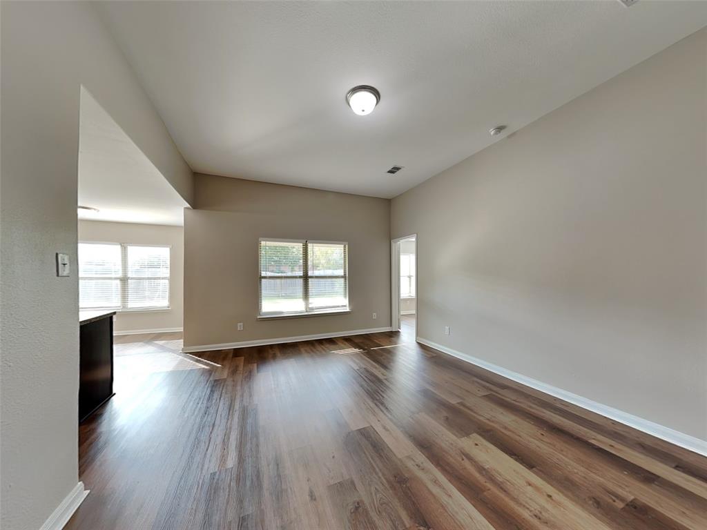 1334 Barrel Drive Dallas, TX 75253 - Photo 4 of 16 an empty room with wooden floor and windows