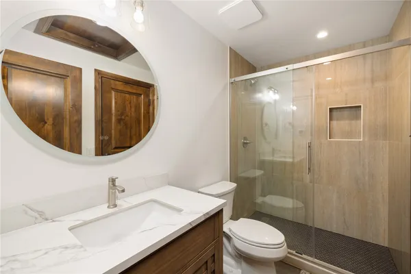 a bathroom with a sink a toilet and shower