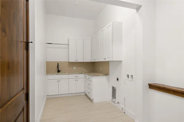 a kitchen with white cabinets and sink