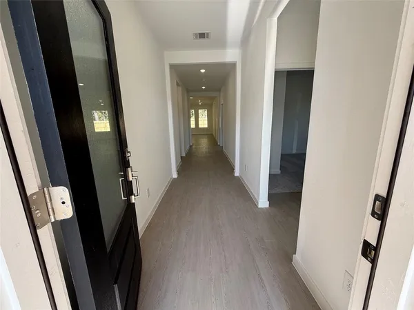 a view of a hallway with wooden floor
