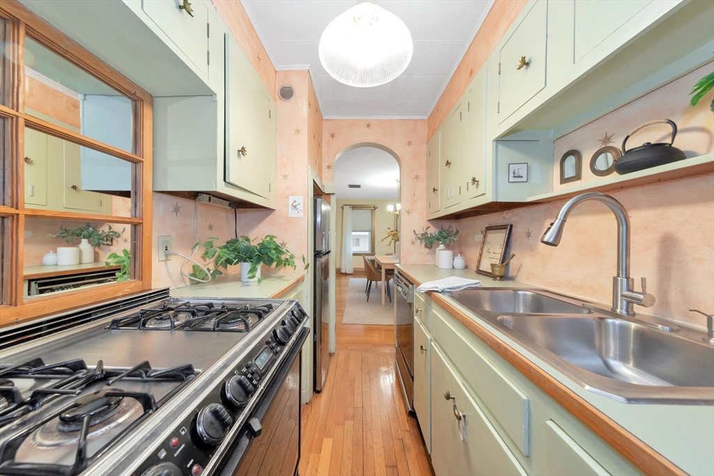 107 Hibbert Street Arlington, MA 02476 - Photo 17 of 40 a kitchen with stainless steel appliances granite countertop a sink stove and cabinets