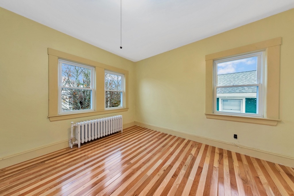 107 Hibbert Street Arlington, MA 02476 - Photo 29 of 40 a view of a room with wooden floor chandelier and windows