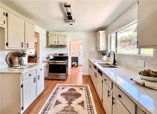 a kitchen with stainless steel appliances a stove sink and cabinets