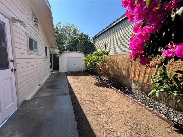 a pathway of a house with wooden fence