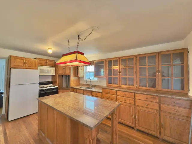 a kitchen with stainless steel appliances granite countertop a refrigerator a stove and a sink with cabinets