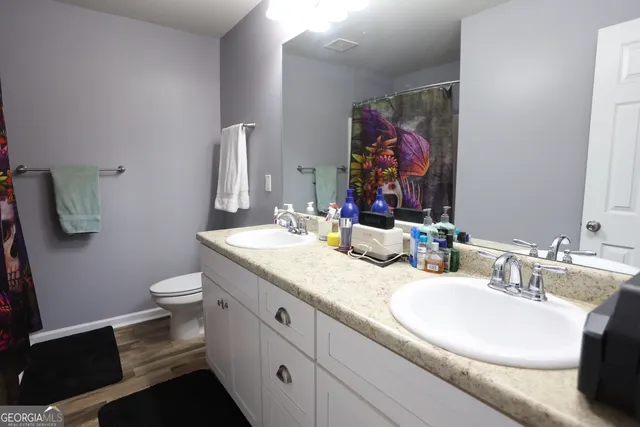 a bathroom with a granite countertop toilet sink and mirror
