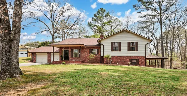 a front view of a house with a yard and trees