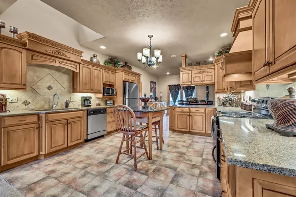 a kitchen with stainless steel appliances granite countertop a sink and cabinets