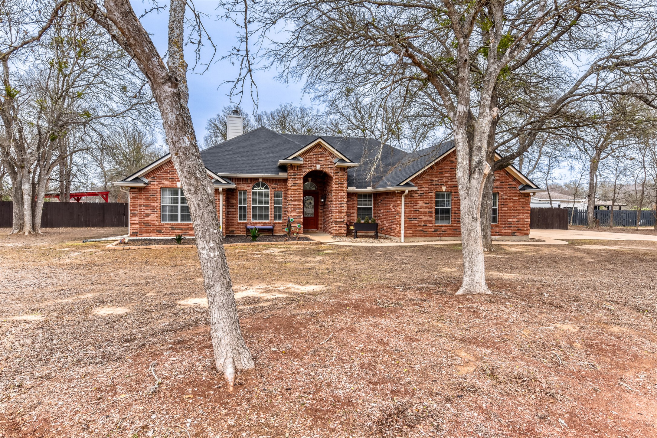 104 Spring Branch Bastrop, TX 78602 - Photo 4 of 32 a front view of a house with a yard covered in snow