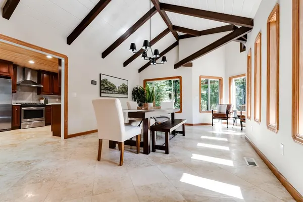 a dining room with furniture and a floor to ceiling window