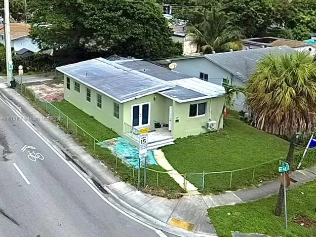 aerial view of a house with a yard and potted plants