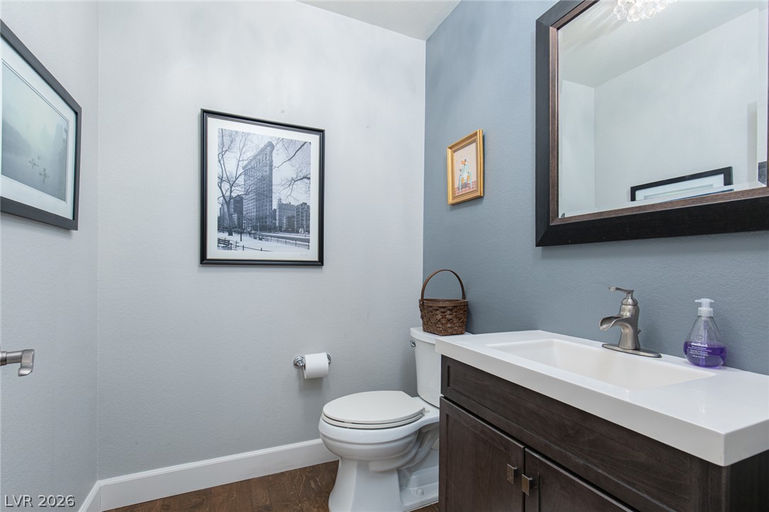 22 Douglas Grove Road Henderson, NV 89052 - Photo 39 of 72 A well-appointed powder room features a dark wood vanity, crisp white counter, and modern fixtures.